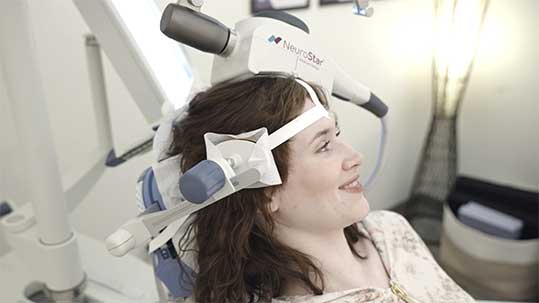 TMS therapy for depression section image for Sonder in Minnesota. Shows woman in NeuroStar TMS therapy treatment chair.